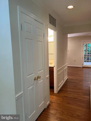 an empty room with wooden floor fire place and windows