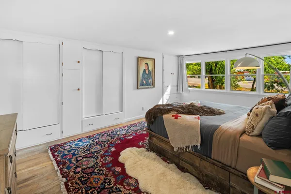a bedroom with a bed and a painting on the wall