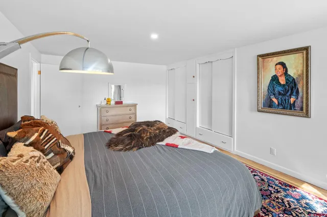 a bedroom with a bed and a painting on the wall