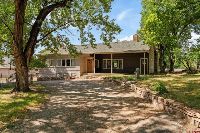 a front view of a house with a tree
