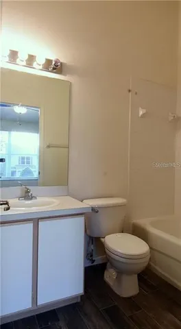 a bathroom with a toilet a sink and mirror