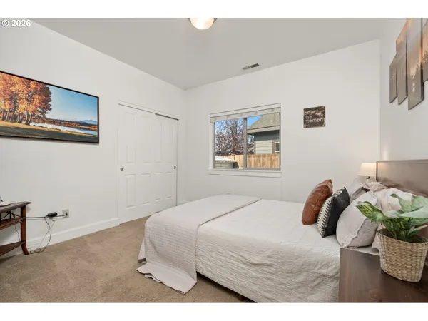 a bedroom with a bed and a painting on the wall