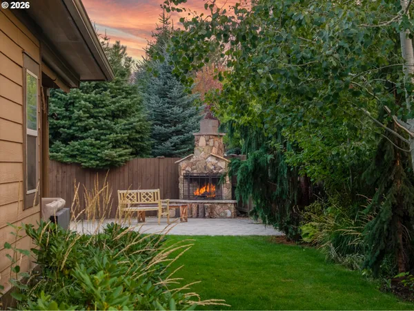a view of a chair and table in backyard of the house