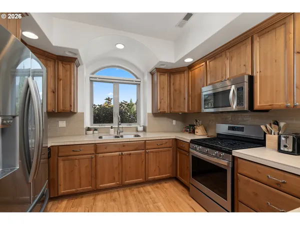 a kitchen with stainless steel appliances a sink stove and refrigerator