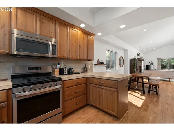 a kitchen with stainless steel appliances granite countertop a stove microwave and cabinets