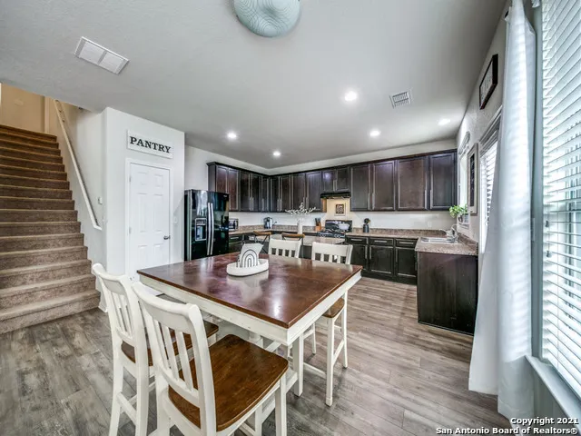 a kitchen with kitchen island a stove a table and chairs in it