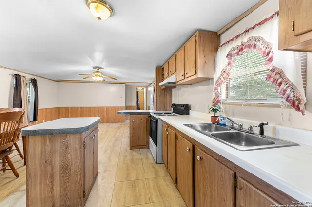 a kitchen with stainless steel appliances granite countertop a sink and a refrigerator
