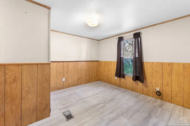 a view of a room with wooden floor and a window