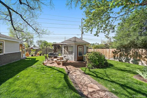 a view of a chair and table in backyard of the house
