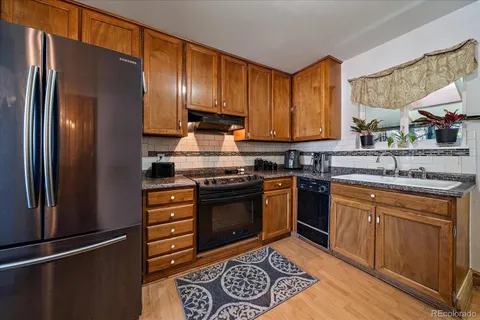 a kitchen with granite countertop stainless steel appliances and wooden cabinets