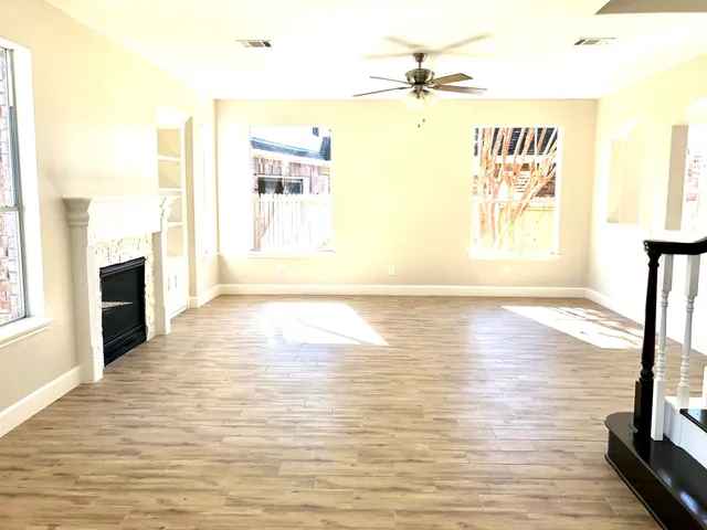 a view of a hallway with wooden floor and staircase