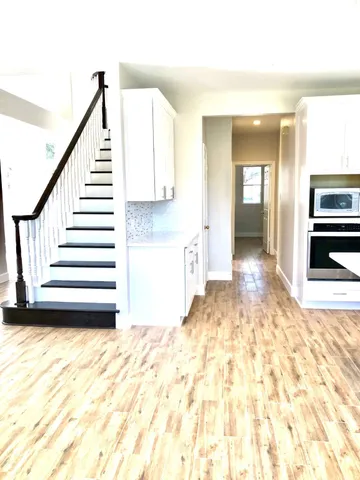 a view of a hallway with wooden floor and staircase