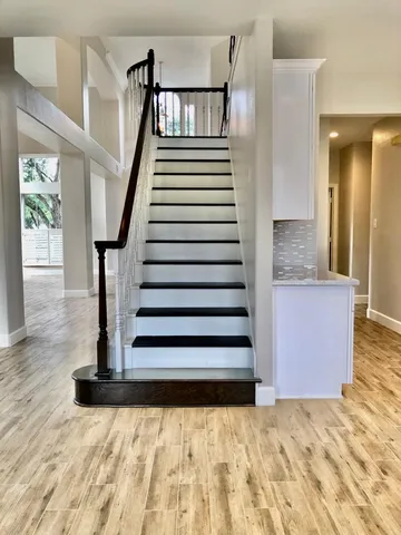 a view of a bedroom with wooden floor and windows