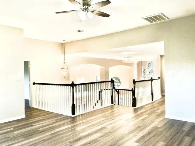 a view of a hallway with wooden floor and staircase