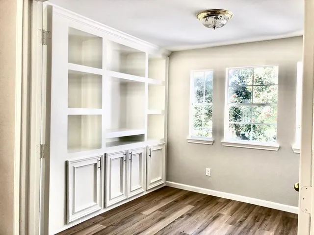 a view of a room with wooden floor and windows