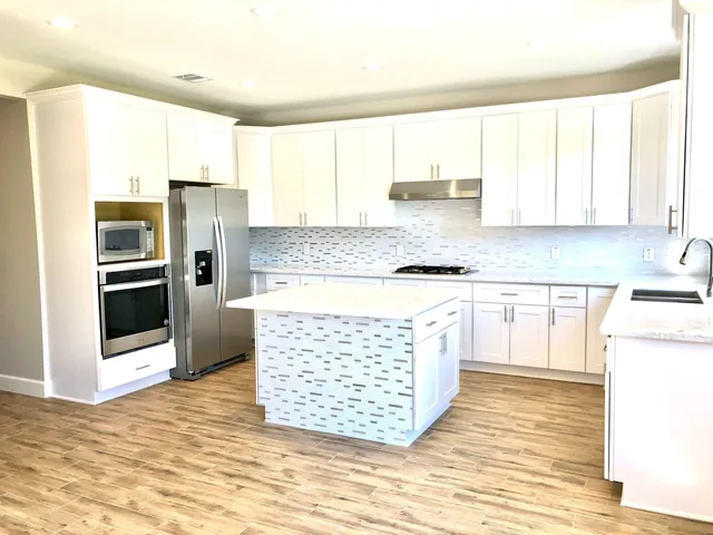a kitchen with stainless steel appliances granite countertop a refrigerator sink and cabinets