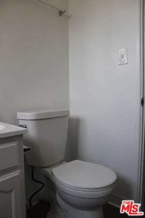 a white toilet sitting next to a shower