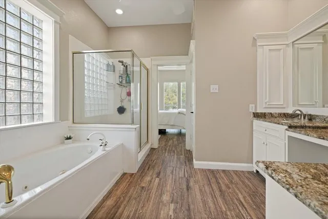 a spacious bathroom with a granite countertop tub sink and shower
