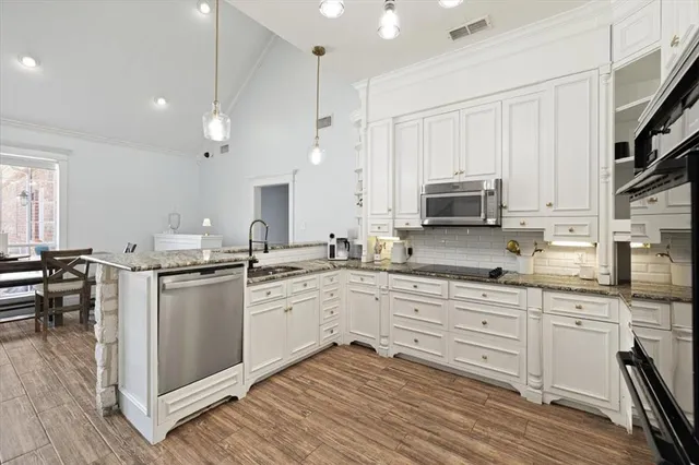 a kitchen with granite countertop white cabinets and white appliances