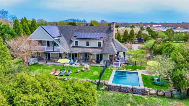 an aerial view of a house with swimming pool garden and mountain view in back