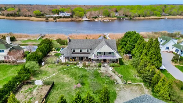 an aerial view of a house with a yard and lake view