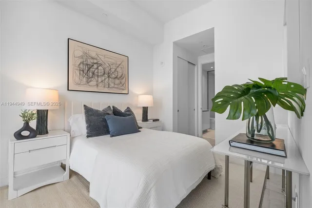 a bedroom with bed and a potted plant