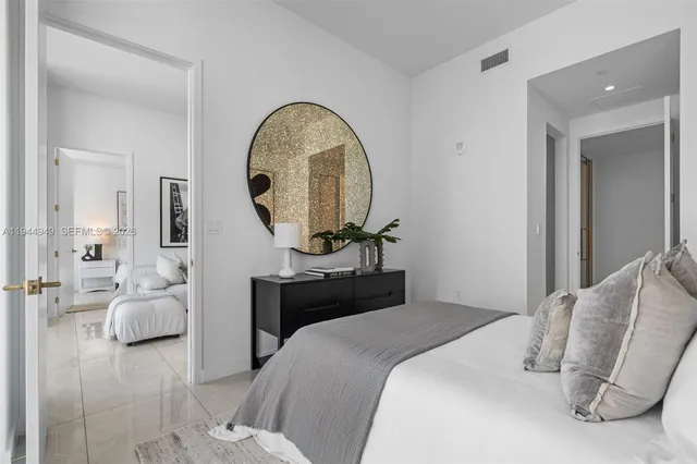 a bedroom with bed and a mirror