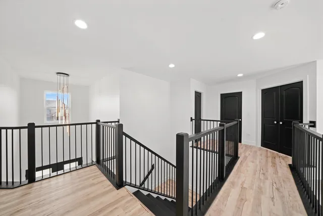 a view of a hallway with wooden floor and staircase