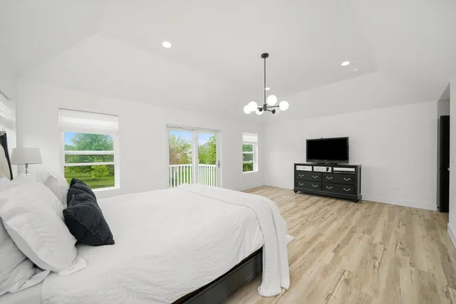 a spacious bedroom with a bed and a flat screen tv