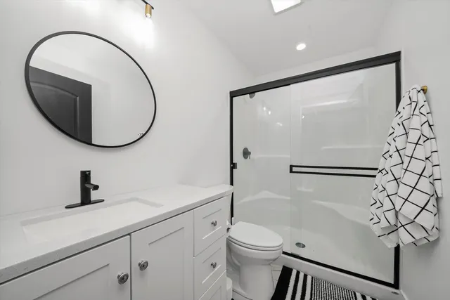 a bathroom with a toilet a sink and a mirror