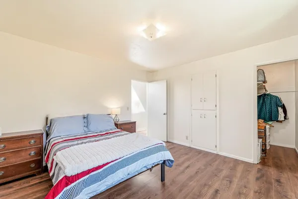 a bedroom with a bed and wooden floor