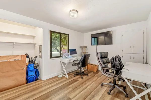 a view of a workspace with furniture and a window