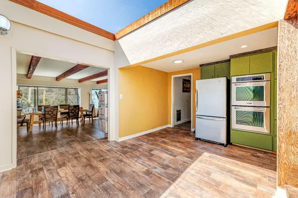 a view of kitchen with furniture and refrigerator