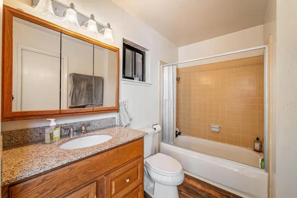 a bathroom with a granite countertop sink toilet and shower
