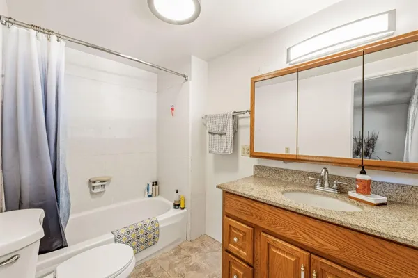 a bathroom with a granite countertop sink toilet and shower