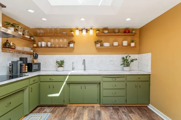 a view of a kitchen with cabinets and wooden floor