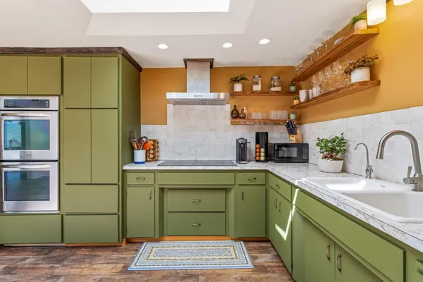 a kitchen with a sink stainless steel appliances granite countertop cabinets and a sink