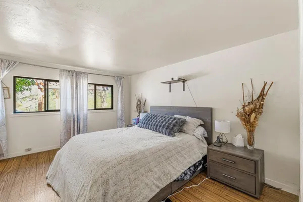 a bedroom with a bed and wooden floor