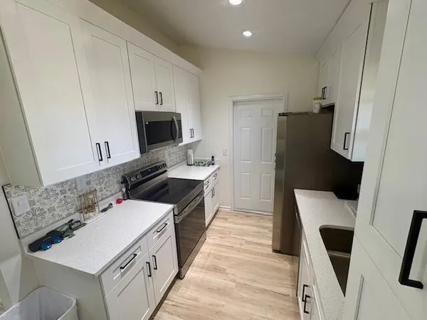 a kitchen with a sink stove and refrigerator