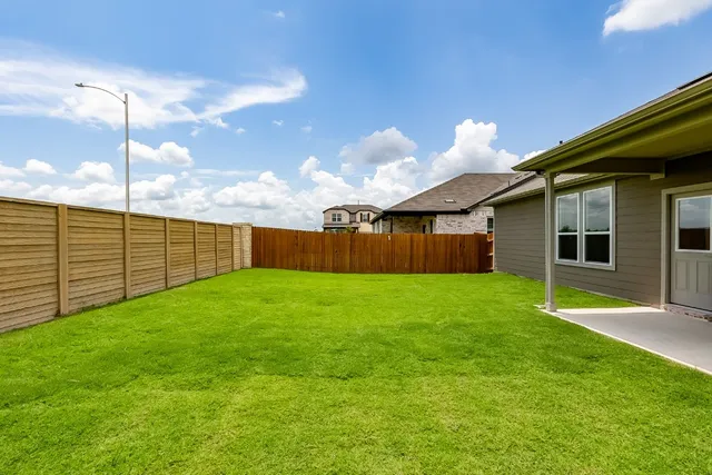 a view of a backyard with wooden fence