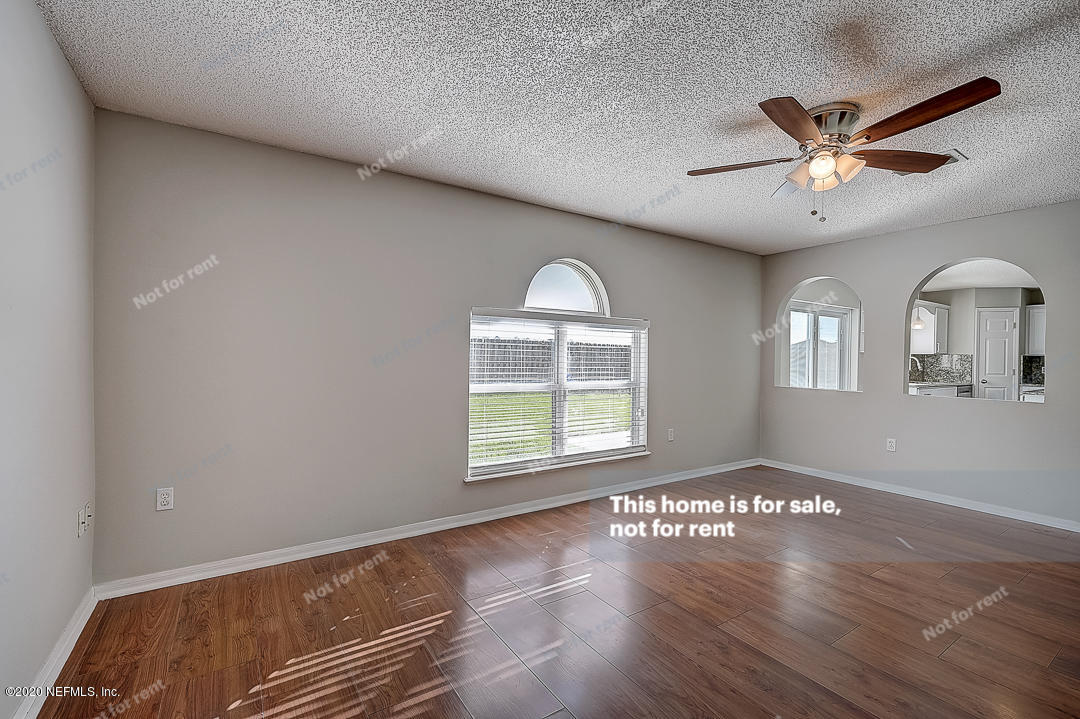 7115 High Bluff Road Jacksonville, FL 32244 - Photo 12 of 45 a view of an empty room with wooden floor and a window