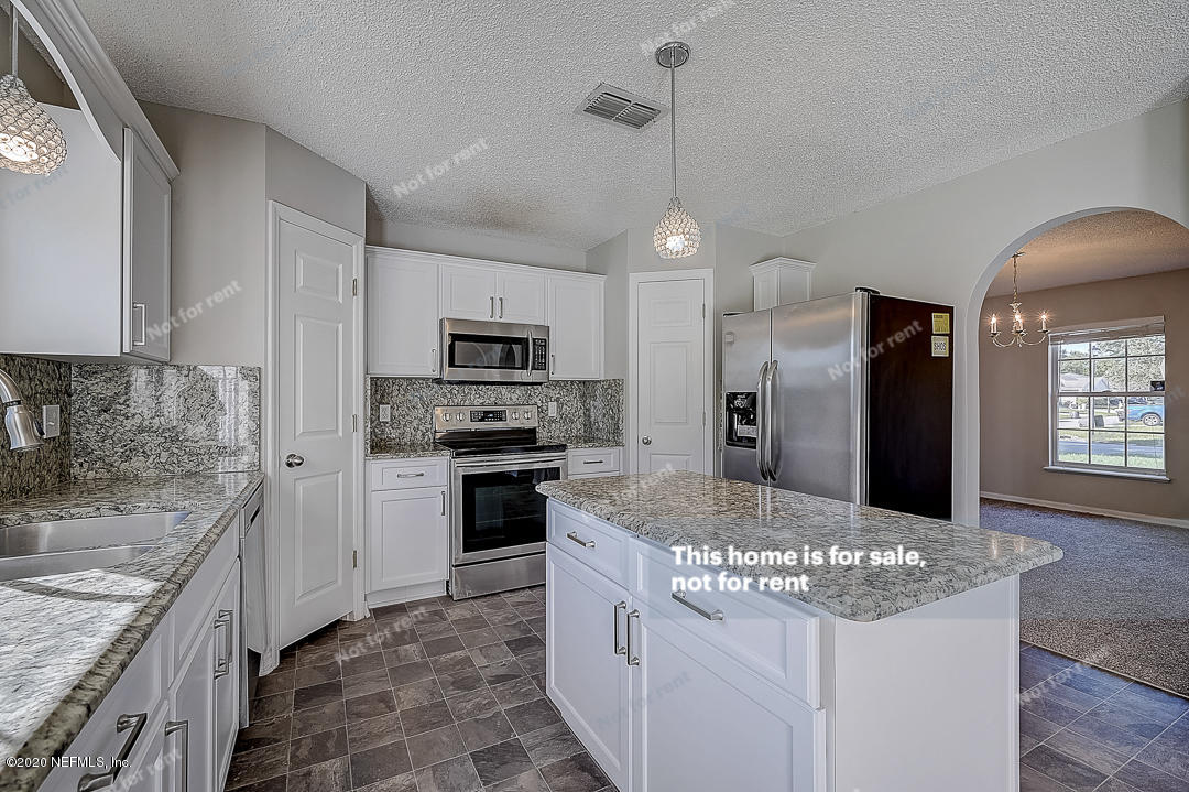 7115 High Bluff Road Jacksonville, FL 32244 - Photo 5 of 45 a kitchen with stainless steel appliances granite countertop a sink stove and refrigerator