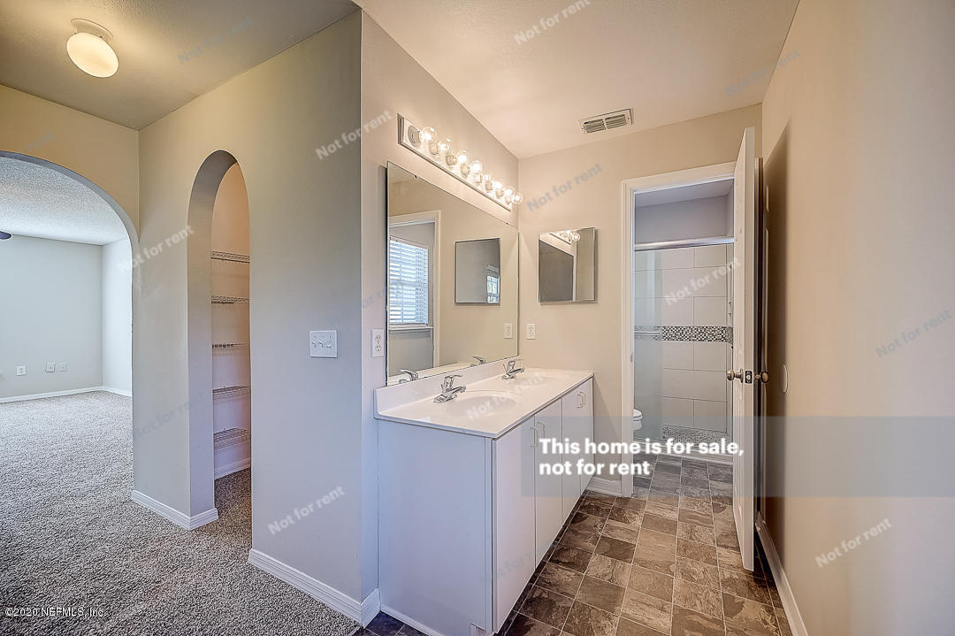 7115 High Bluff Road Jacksonville, FL 32244 - Photo 6 of 45 a bathroom with a sink a mirror and a shower