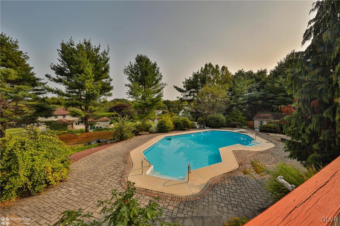 517 Roberts Road Nazareth, PA 18064 - Photo 12 of 50 a view of a swimming pool with lawn chairs under an umbrella