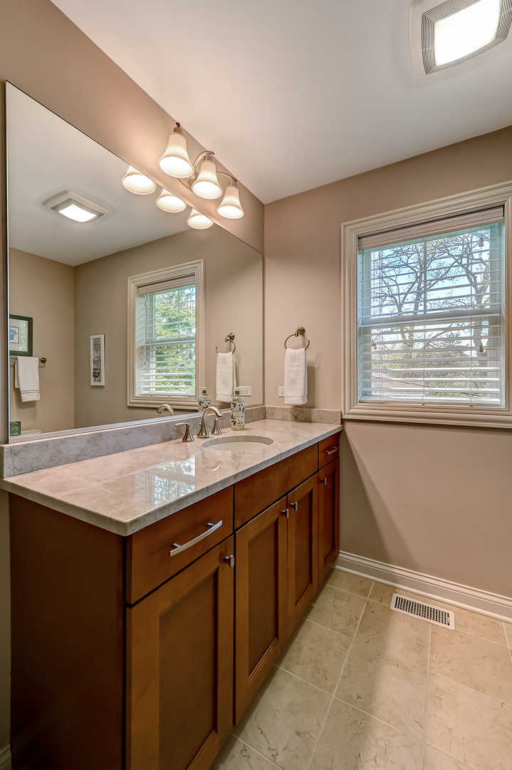 5607 Hillcrest Road Downers Grove, IL 60516 - Photo 27 of 50 a bathroom with a granite countertop sink and a large mirror