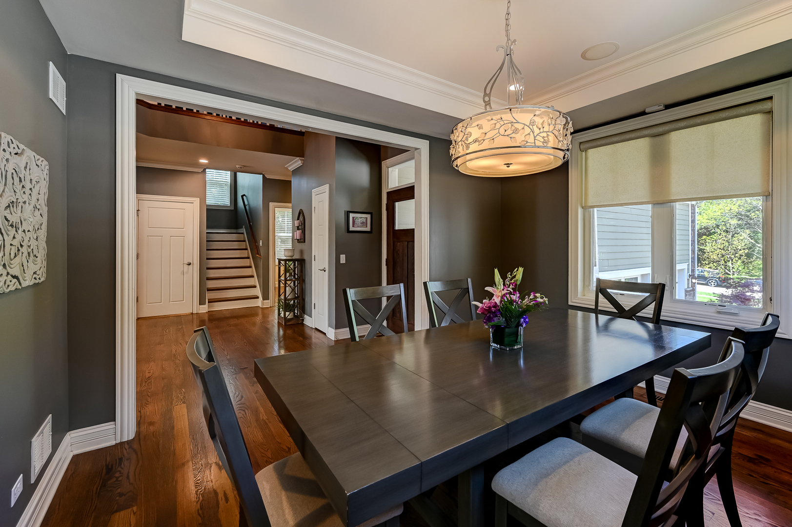 5607 Hillcrest Road Downers Grove, IL 60516 - Photo 8 of 50 a dining room with wooden floor a chandelier a wooden table and chairs