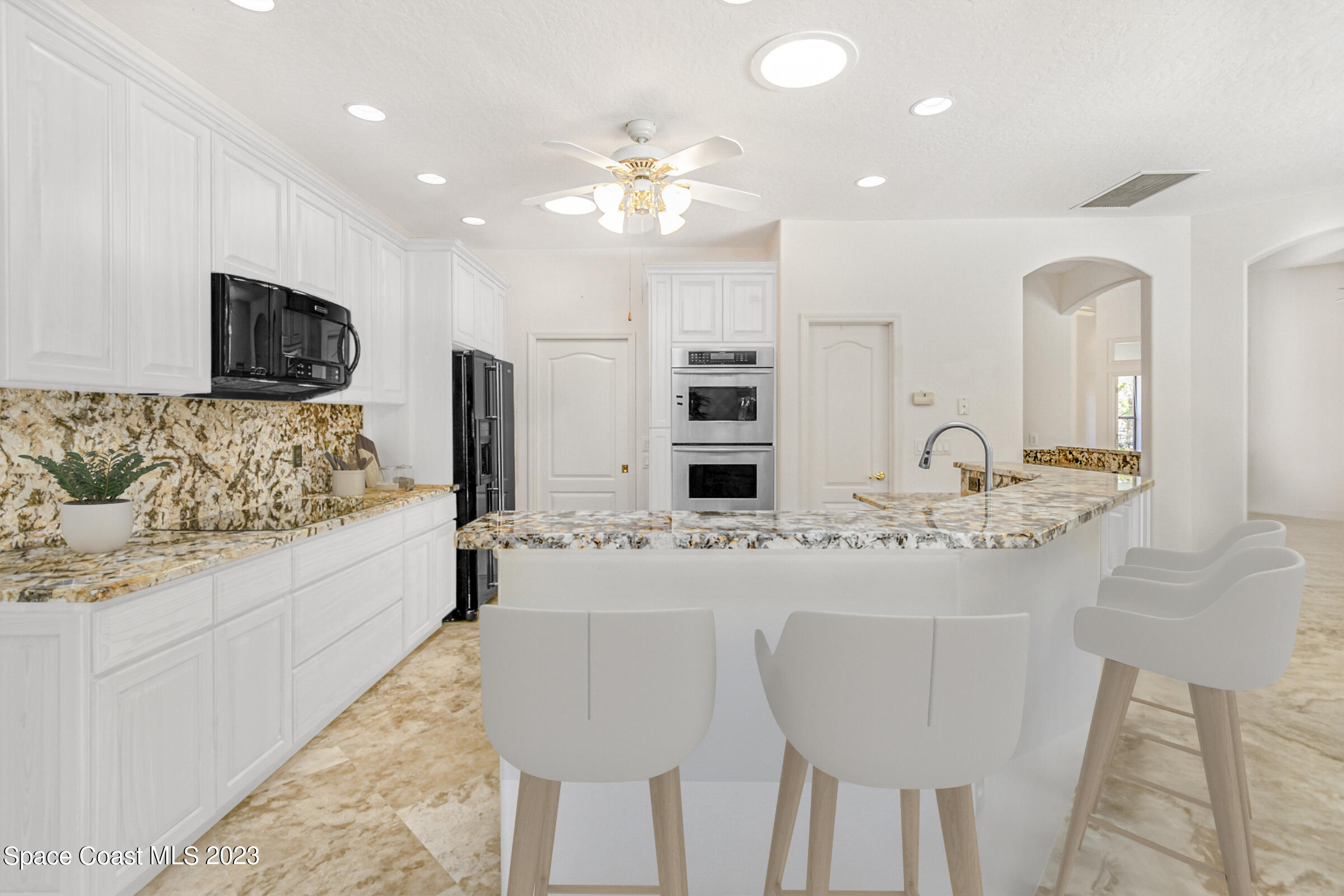 271 Deer Run Road Palm Bay, FL 32909 - Photo 8 of 61 a spacious kitchen with stainless steel appliances kitchen island granite countertop a sink and a white cabinets