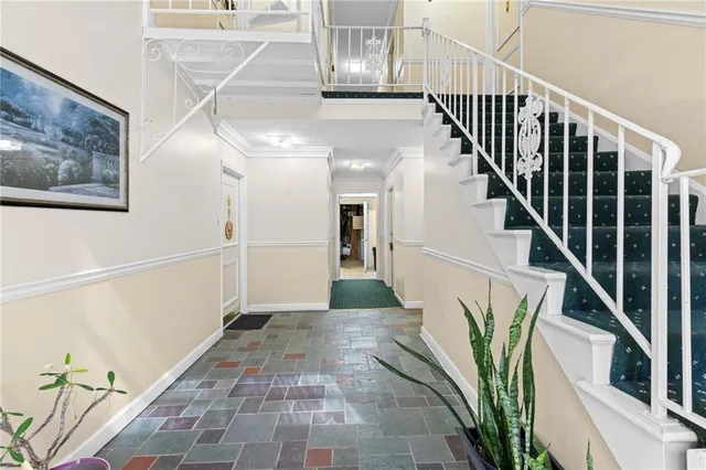 a hallway with painting and a potted plant