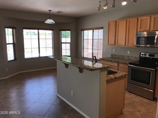a kitchen with stainless steel appliances granite countertop a stove a sink and a microwave