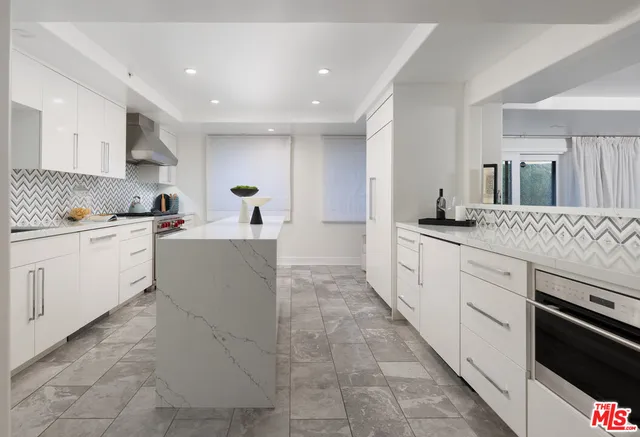a large white kitchen with stainless steel appliances granite countertop a sink and dishwasher